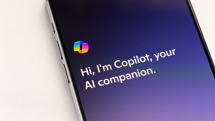 Smartphone met Microsoft Copilot op het scherm en de tekst ‘Hi, I’m Copilot, your AI companion.’