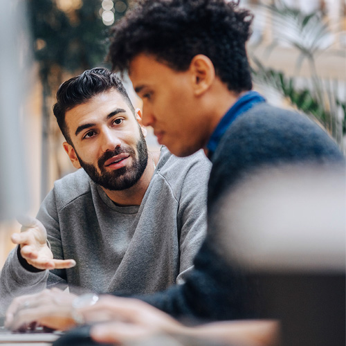 2 men at a table talking