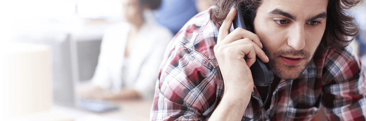 Guy bending over on the phone in the office