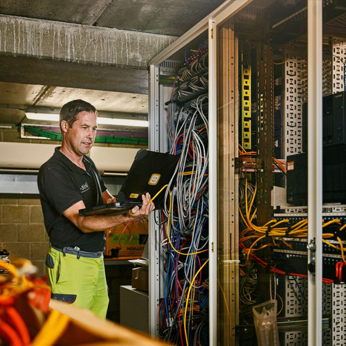 Group of operators at work. Call center. Focus on young man receptionist in headset at customer service. Business concept and casual clothing style