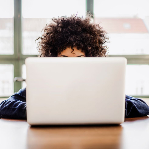 girl behind a white laptop