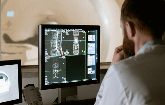 Ziekenhuismedewerker die naar MRI-scan kijkt op computer