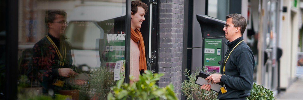A woman stands at the door and smiles at Technician Bjorn