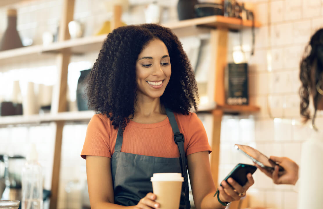 Betalen met gsm: een klant houdt de smartphone tegen de betaalterminal
