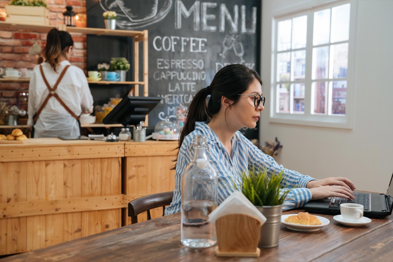 freelancer in glasses using laptop sit at cafe