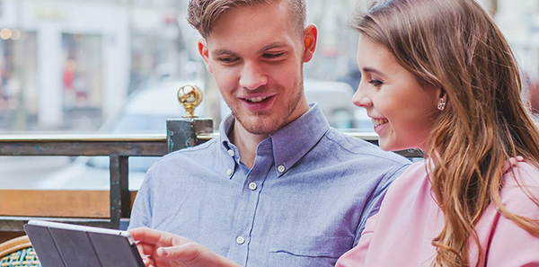 Two people talking and pointing on tablet