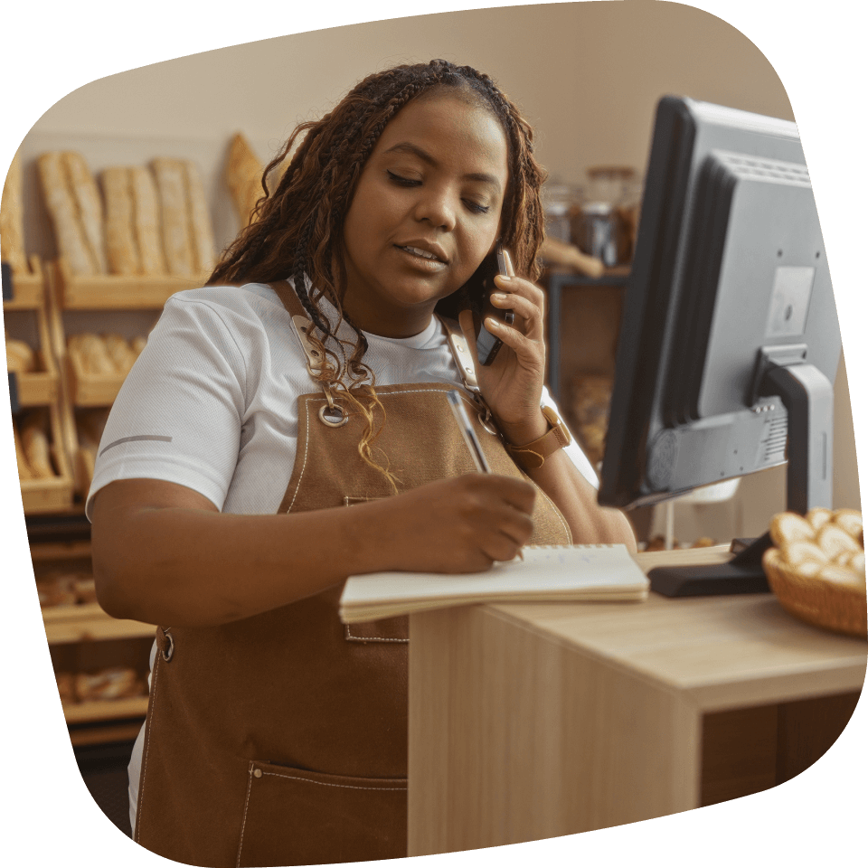 Dame bij de bakker die aan de telefoon een bestelling aanneemt