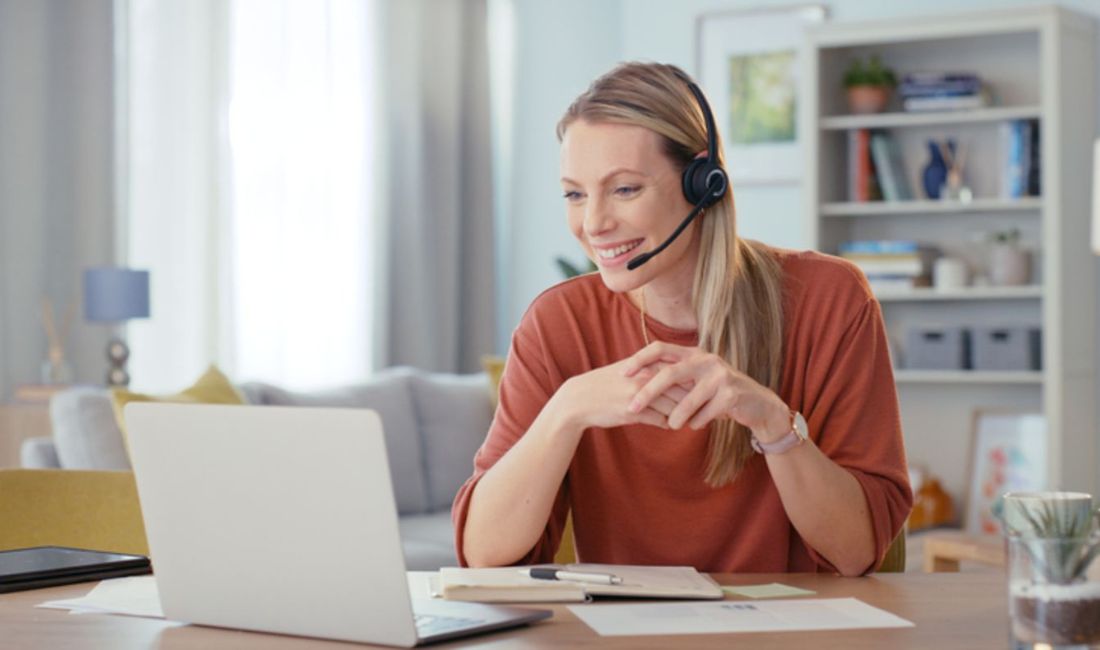 woman with headset in front of laptop