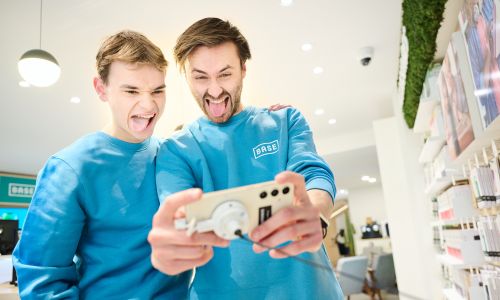 Two men with Base sweaters taking a selfie with mobile in shop