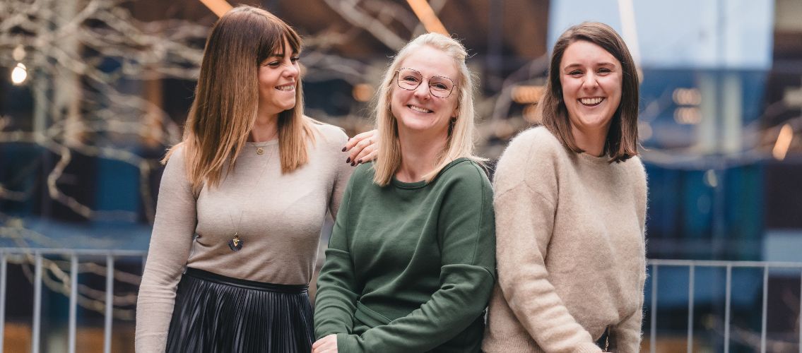 three female colleagues posing