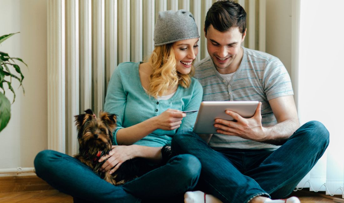 man, woman and dog with tablet on the floor
